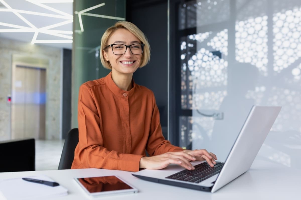 A happy woman working at her laptop, working with Kenwood company concept