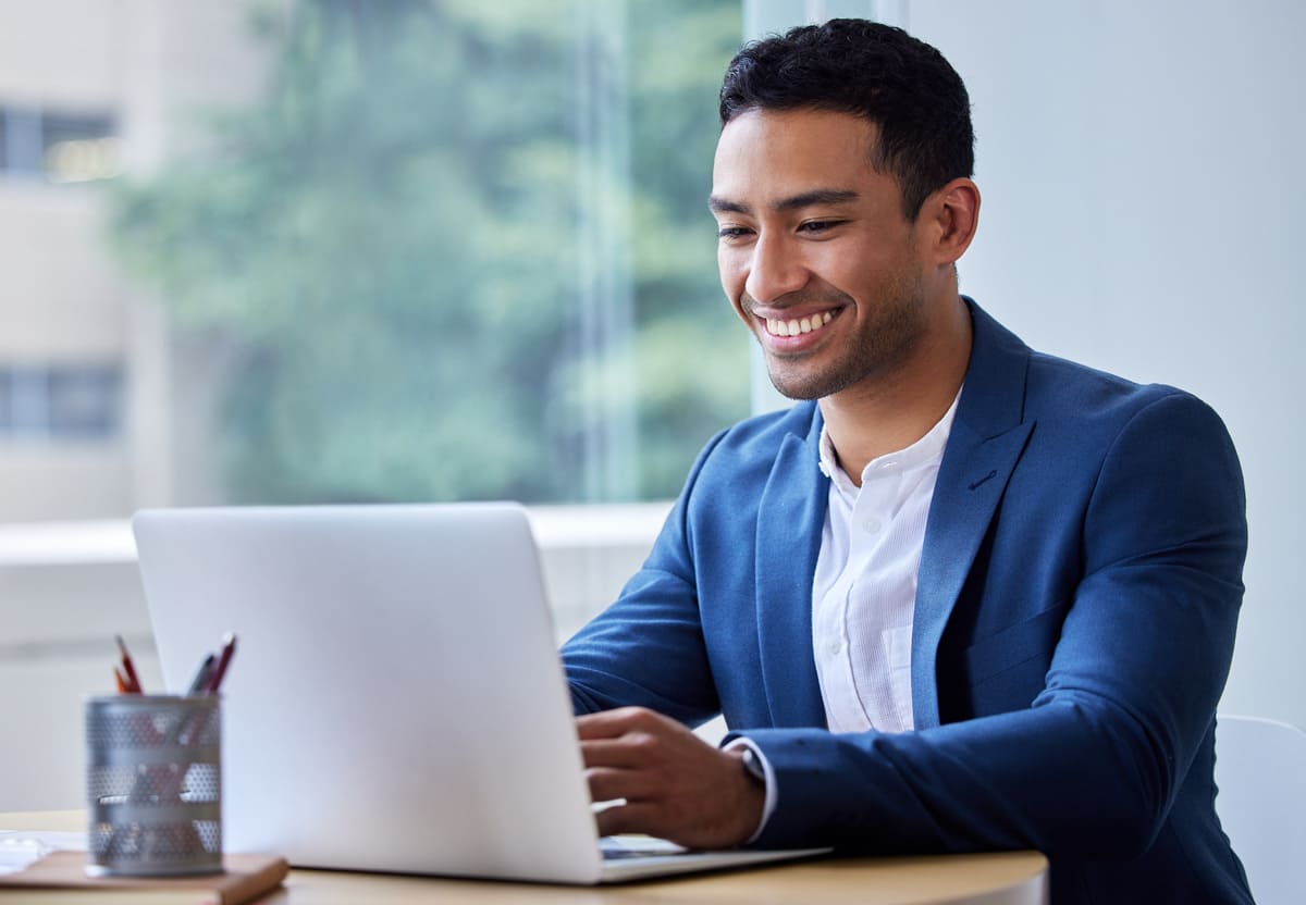 A man in a suit working on a laptop