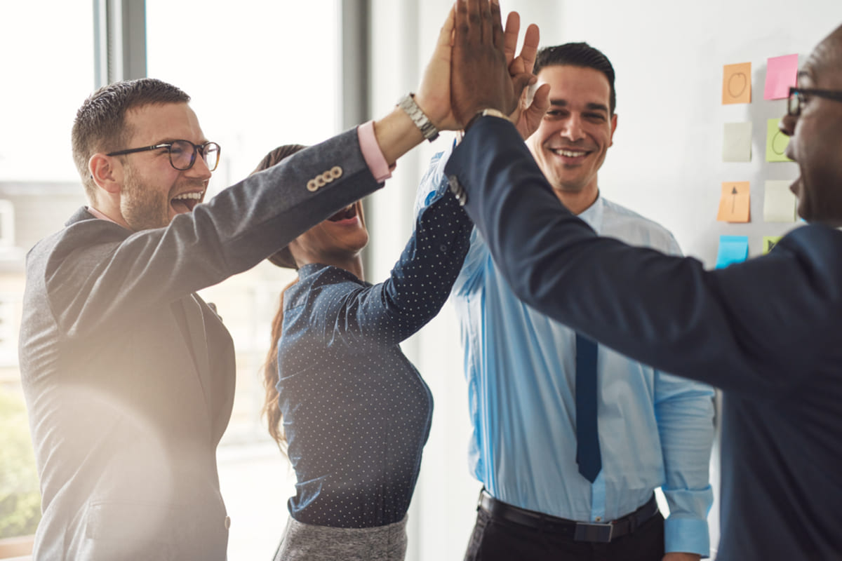 Business colleagues give high fives for success, real estate investment partnerships concept