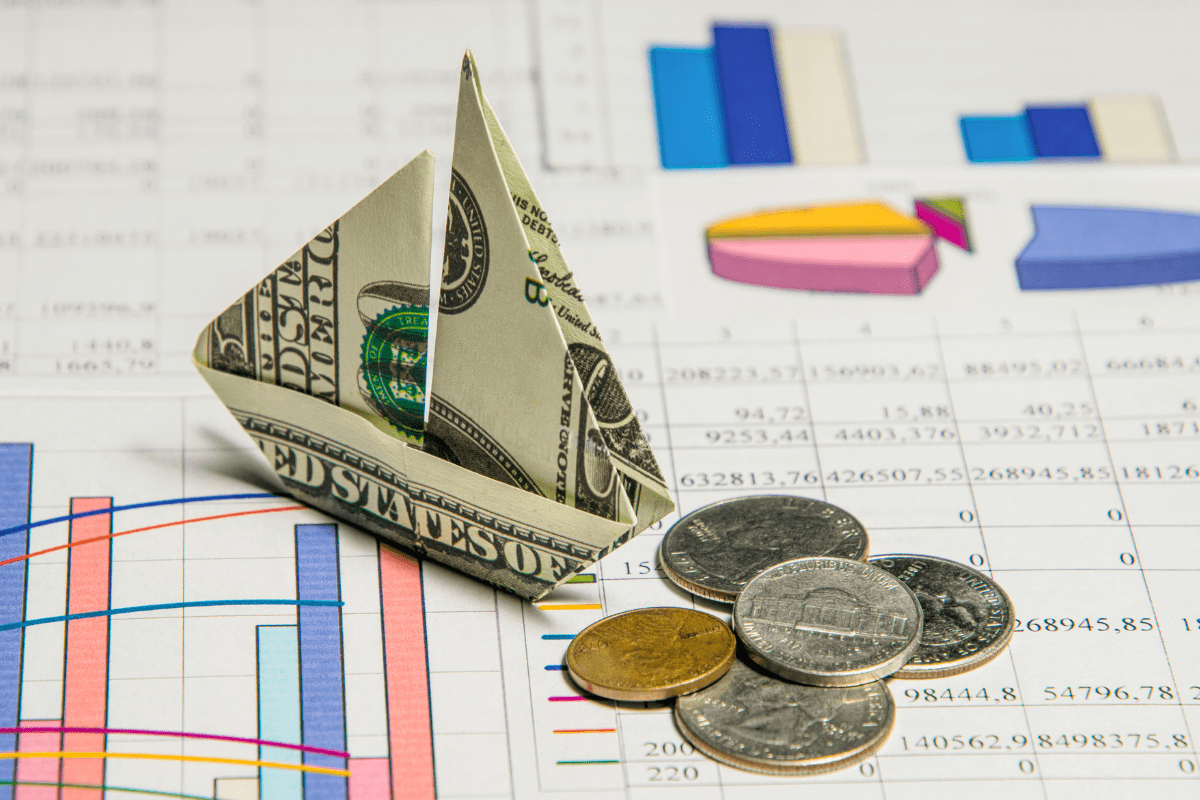 Dollar bill folded into sailing boat shape navigating through graphs