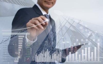 Double exposure of businessman analyzing financial graph with office buildings in background.