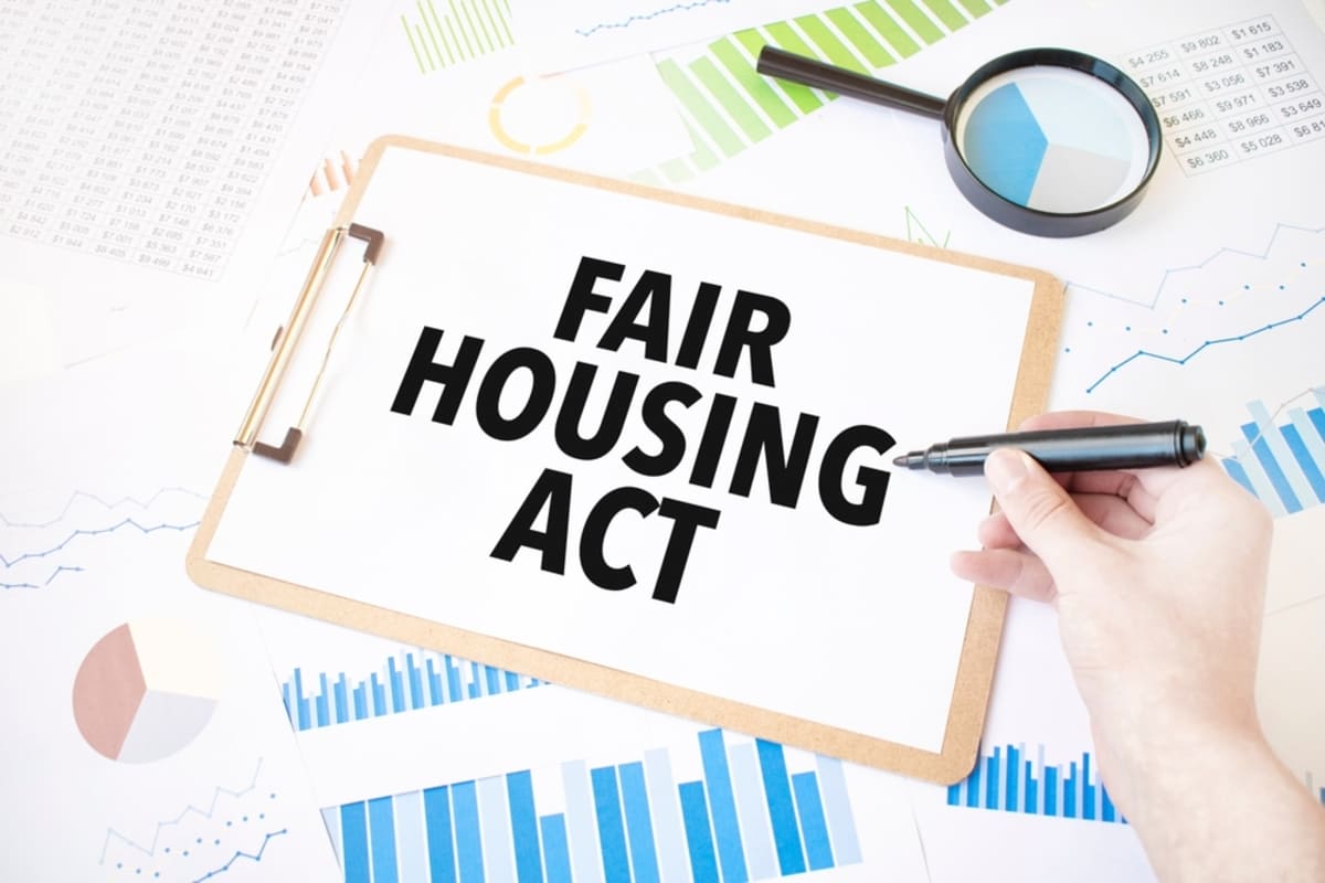 Fair Housing Act written on a clipboard in front of graphs