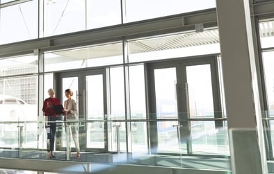 Two businesswomen discussing commercial real estate contract in office building