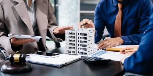 Professional team around a model of a commercial building