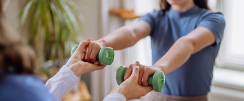 Teen Doing Arm Exercises with Help Indoors