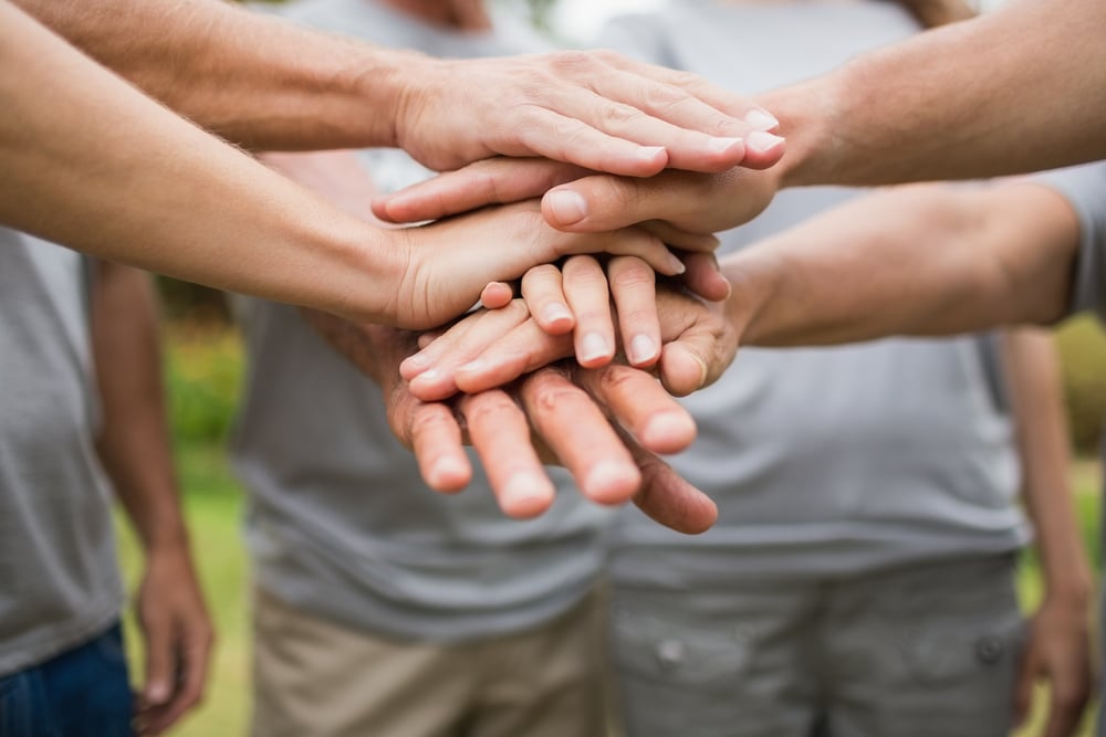 A group of hands together represents the Kenwood Community and our philosophy. 