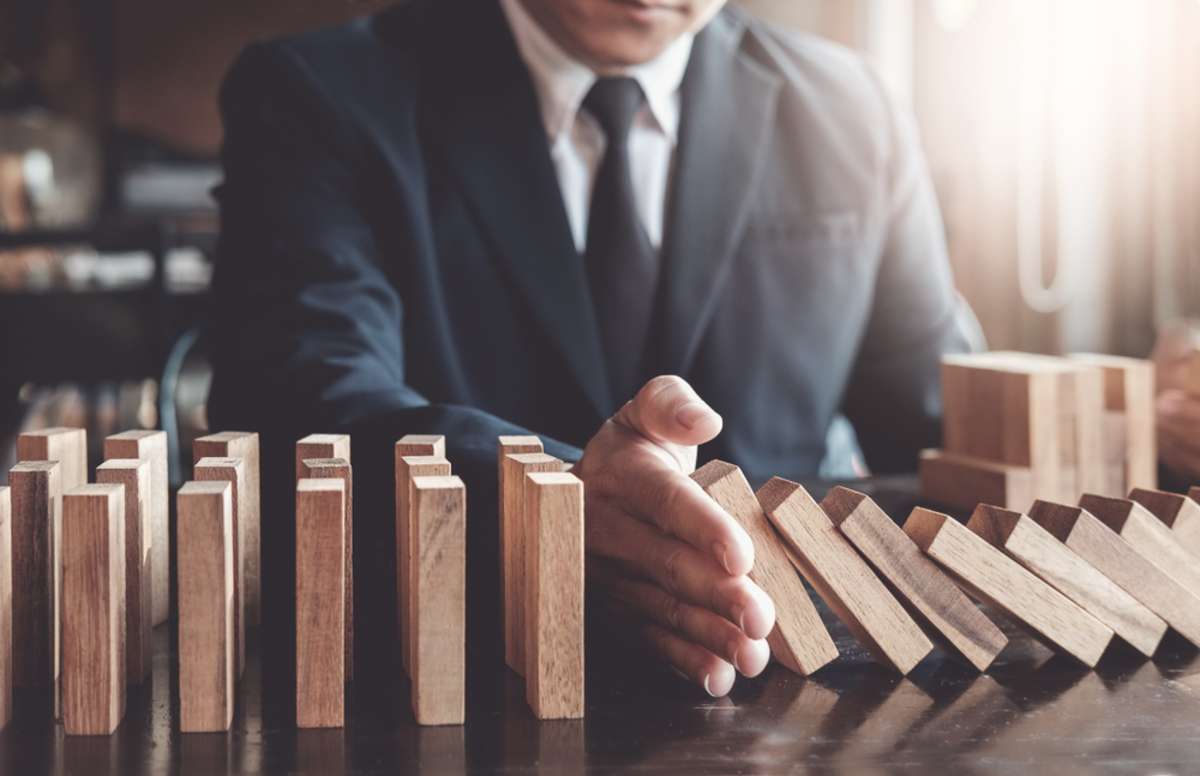 A hand stops falling blocks, retail business insurance protection concept