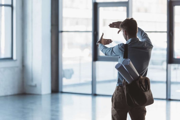 Businessman looking at an empty commercial space for an office lease