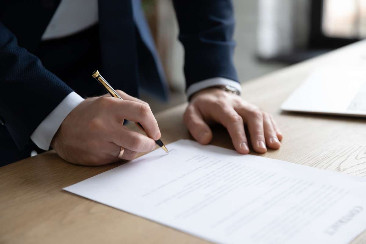 Close-up of hands signing a lease to rent a building in Baltimore