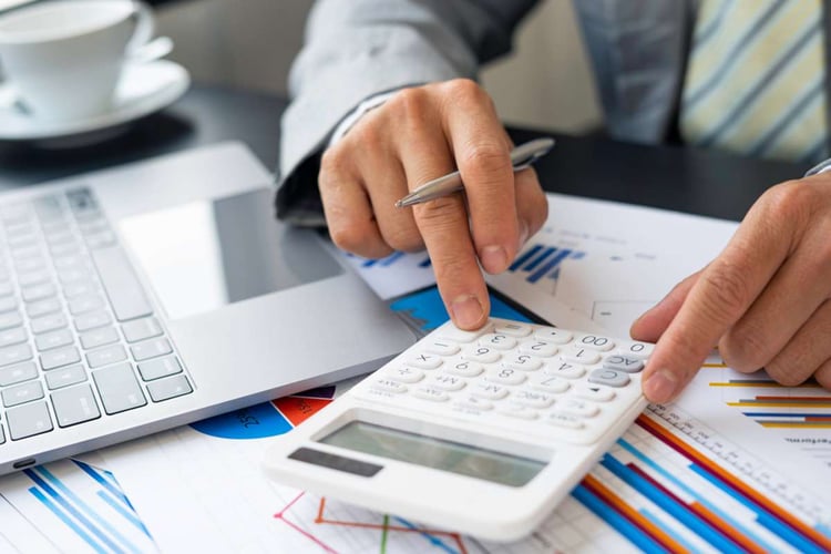 Man using a calculator and reviewing numbers to budget for a business rental space-1