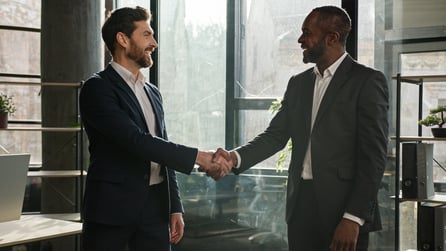 Two property owners shaking hands to represent making a conservative commercial real estate investing deal.