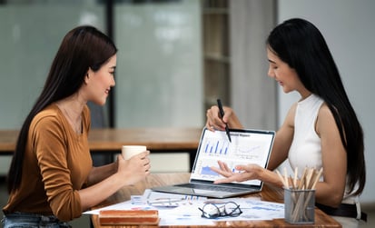 Two investors reviewing numbers to represent what investors miss when comparing REITs vs. private real estate investments