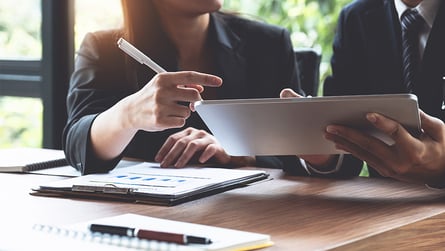 People reviewing research, REIT vs. syndication concept.