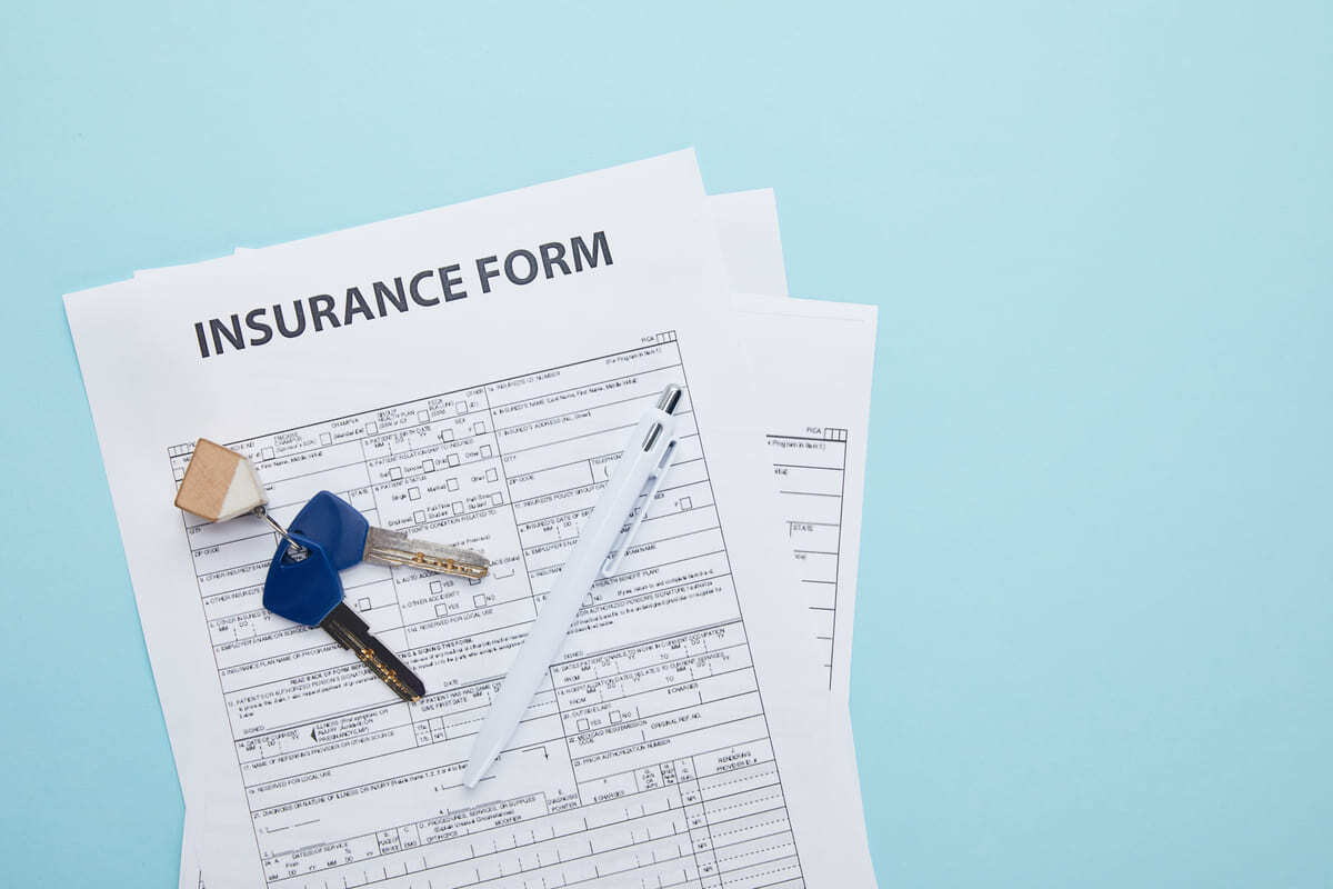 An insurance form with keys on top of it
