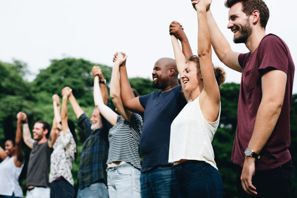 A group of smiling people holding hands together, Kenwood Management Company investor family concept