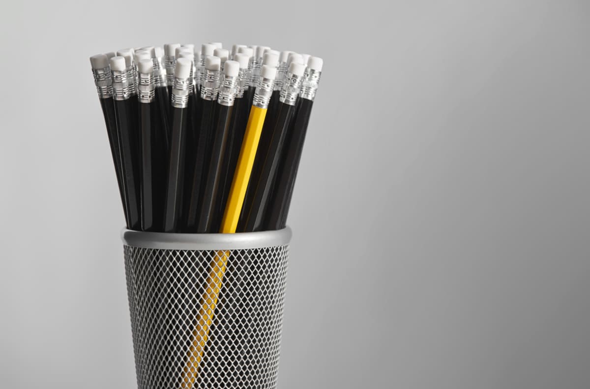  A yellow pencil in a set of black pencils, Kenwood Management property management strategies stand out concept