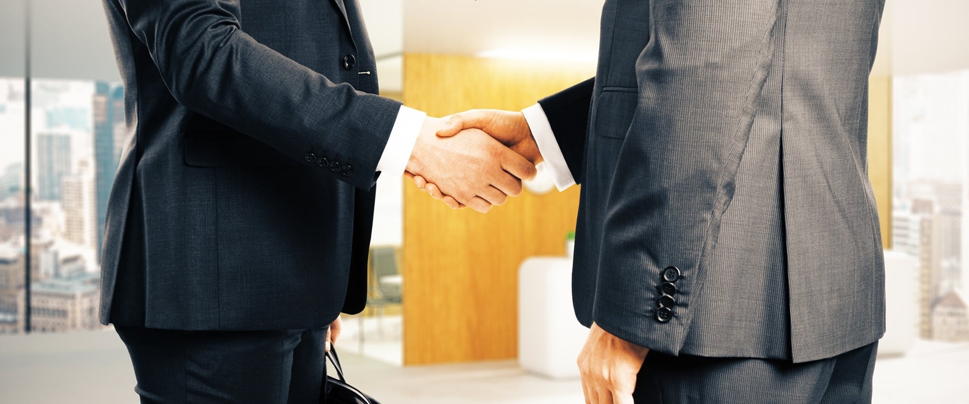 Close Up Of Businesspeople Shaking Hands On Office Interior Background. Partnership Concept