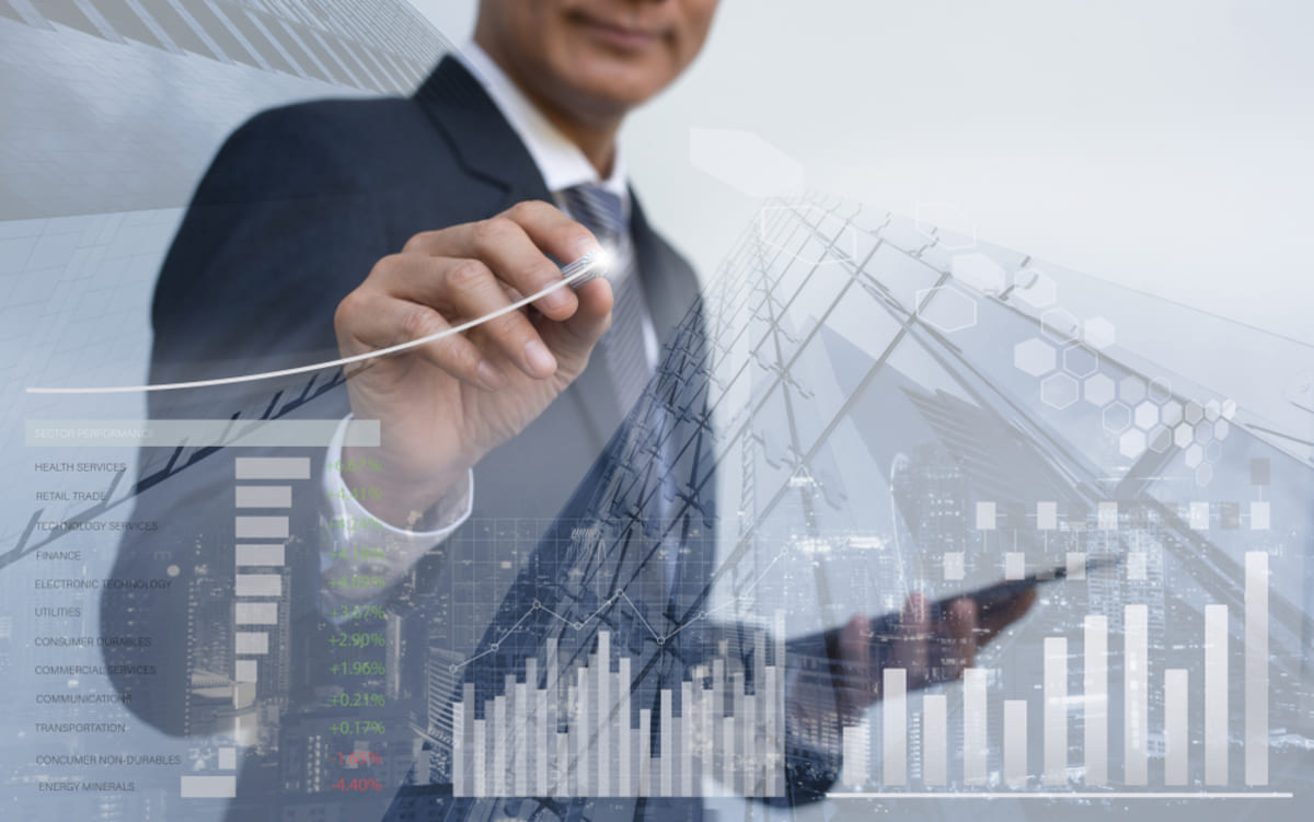 Double exposure of businessman analyzing financial graph with office buildings in background.