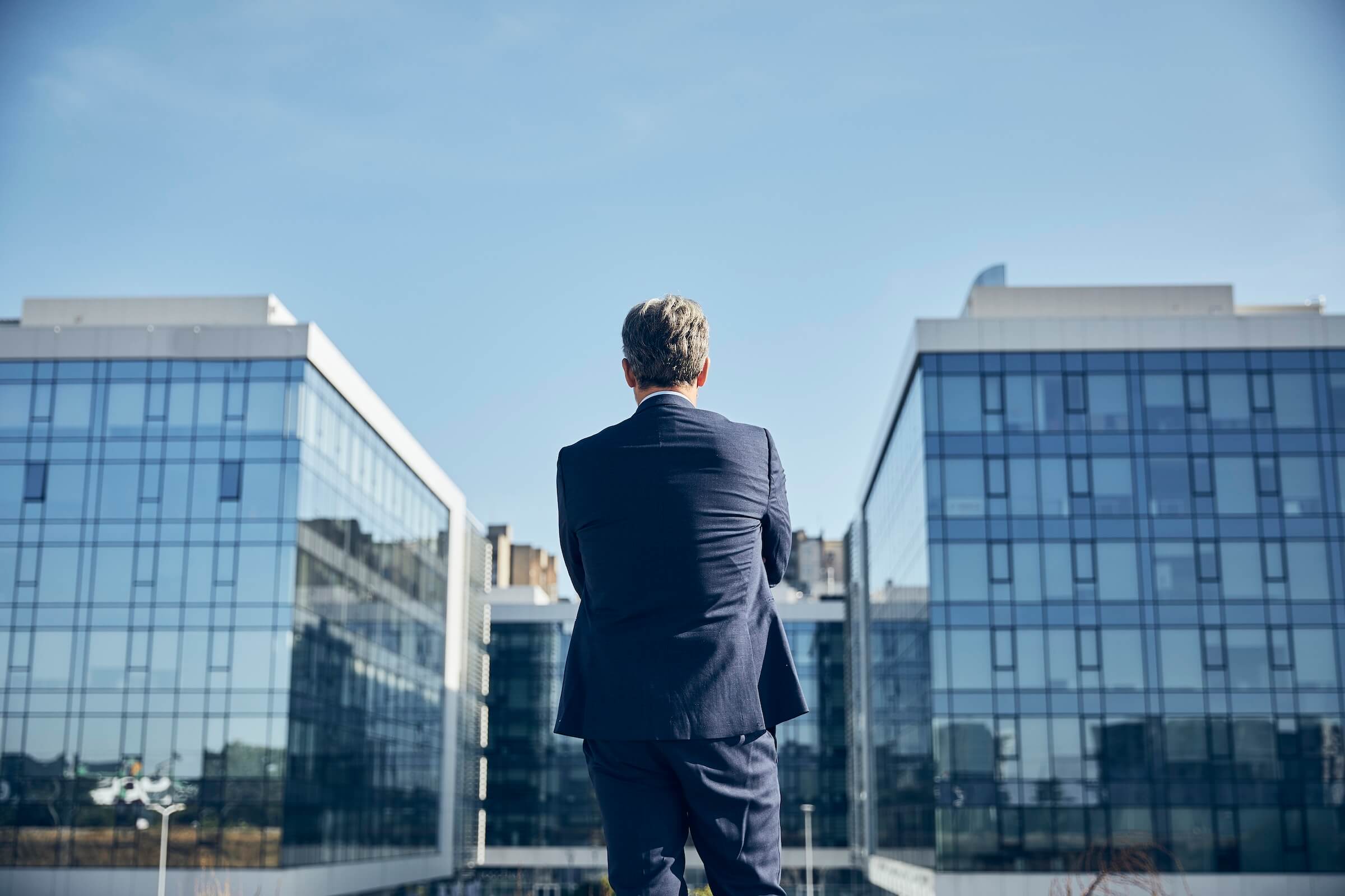 Businessman outside looking at commercial office buildings