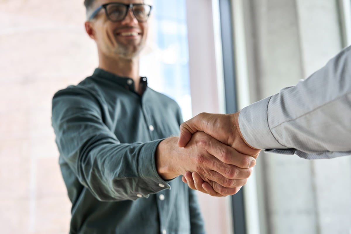 Two people shaking hands, how to invest in real estate with a partner