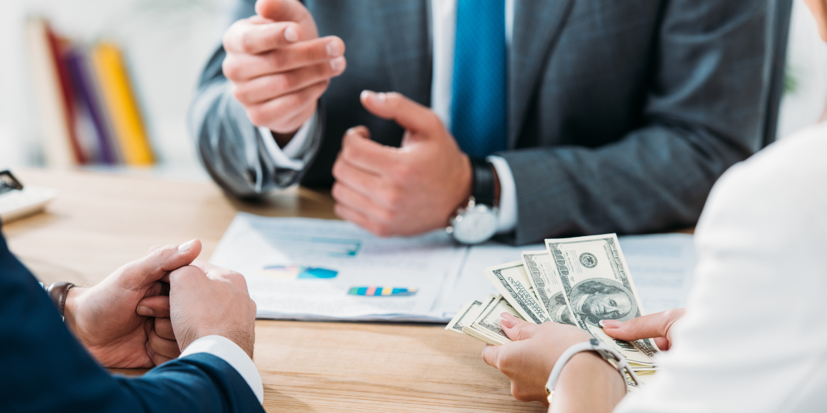 04 selective focus of investor holding money with colleagues at office