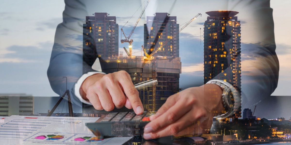 Double exposure of businessman working with calculator and construction crane and building in the evening