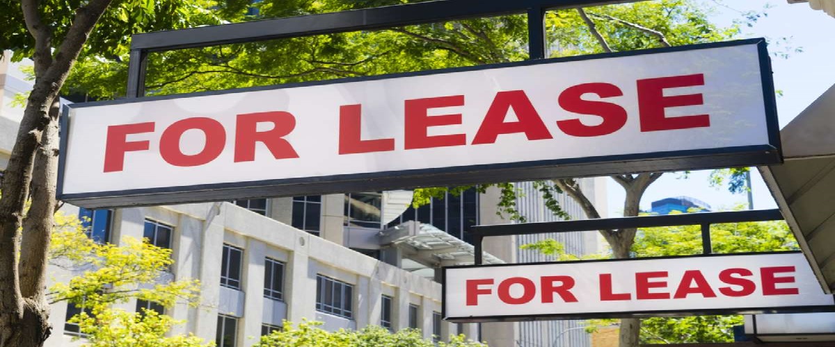 two For Lease signs on display outside buildings during daytime